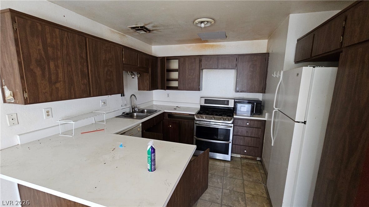 6777 Ledgewood Drive, Las Vegas, NV 89103 A classic U-shaped kitchen layout features wood cabinets and laminate countertops.