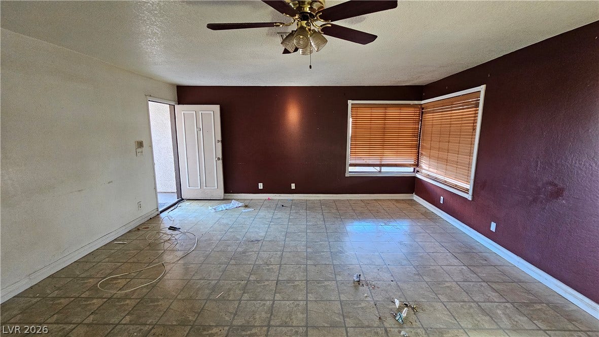 6777 Ledgewood Drive, Las Vegas, NV 89103 Tiled flooring and a large bay window anchor this versatile living space.
