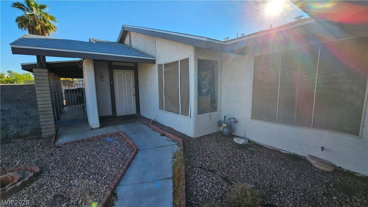 6777 Ledgewood Drive, Las Vegas, NV 89103 A concrete pathway leads to the covered front entryway of this classic stucco home.