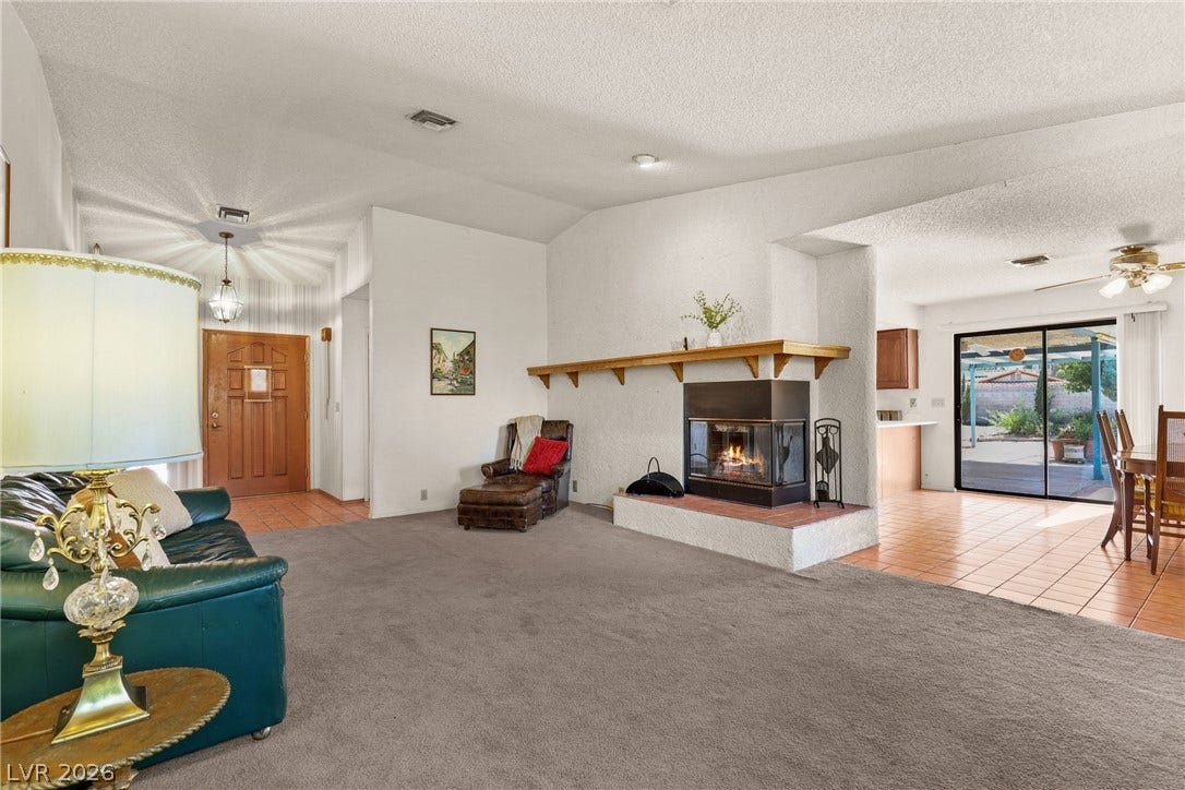5601 Paseo Recallo Court, Las Vegas, NV 89108 An open layout connects the carpeted living space to a tiled dining area and kitchen.