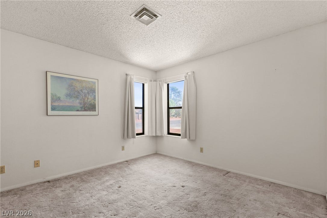 5601 Paseo Recallo Court, Las Vegas, NV 89108 Plush carpeting and corner windows accent this versatile bedroom space.