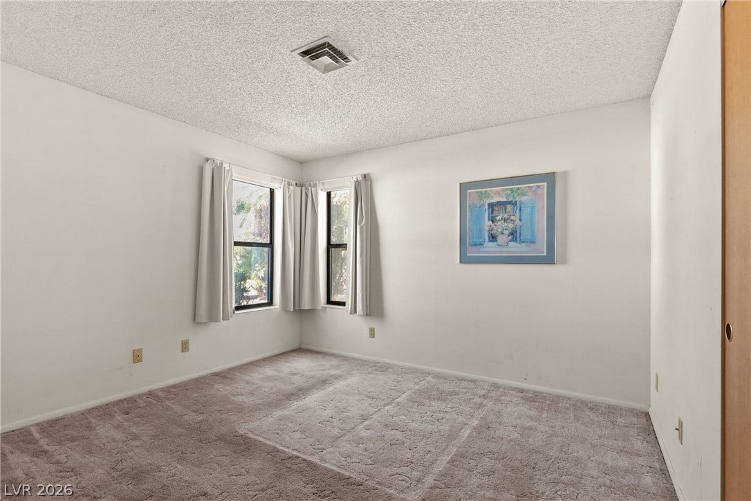 5601 Paseo Recallo Court, Las Vegas, NV 89108 Plush carpet anchors this quiet bedroom illuminated by dual corner windows.
