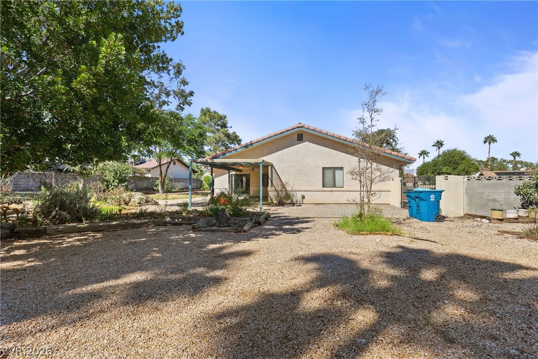 5601 Paseo Recallo Court, Las Vegas, NV 89108 Mature trees shade a spacious gravel yard featuring a covered patio and block fencing.