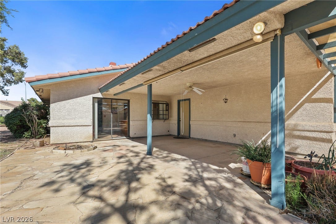 5601 Paseo Recallo Court, Las Vegas, NV 89108 A spacious covered patio features tiled roofing, stucco siding, and stone paving.