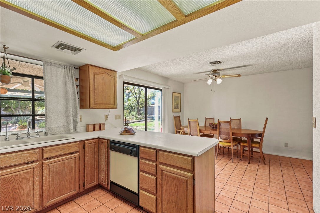 5601 Paseo Recallo Court, Las Vegas, NV 89108 Warm wood cabinetry and tile flooring anchor this functional kitchen and adjoining dining area.