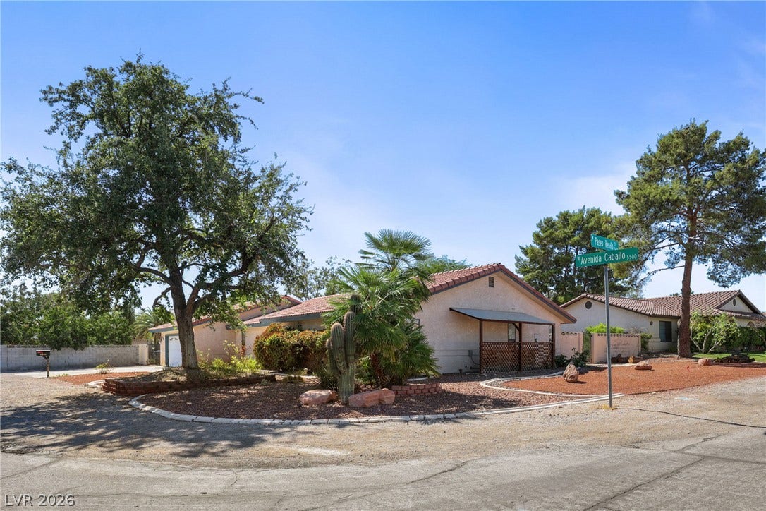 5601 Paseo Recallo Court, Las Vegas, NV 89108 Mature desert landscaping frames a single-level home set on a quiet corner lot.