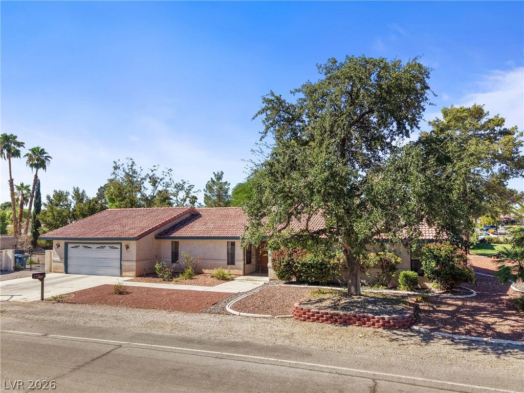 5601 Paseo Recallo Court, Las Vegas, NV 89108 A classic tile roof and manicured desert landscaping define this charming single-story home.