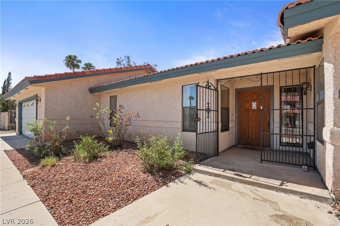 5601 Paseo Recallo Court, Las Vegas, NV 89108 A welcoming gated courtyard entry introduces this classic stucco home topped with Spanish tile roofing.