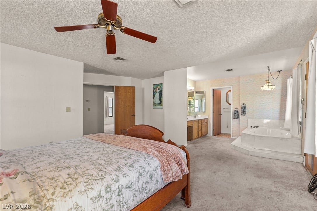 5601 Paseo Recallo Court, Las Vegas, NV 89108 A spacious primary bedroom suite flows directly into a dedicated bath area with soaking tub.