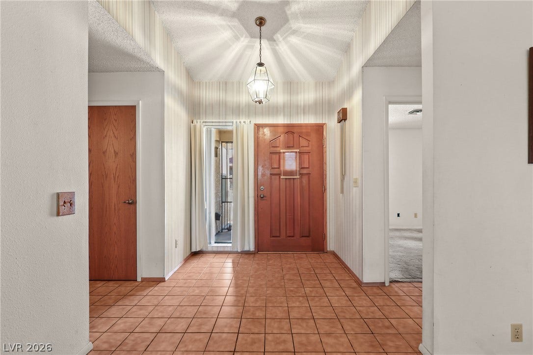 5601 Paseo Recallo Court, Las Vegas, NV 89108 Elegantly designed entry foyer features classic tile flooring and a distinctive vaulted ceiling.