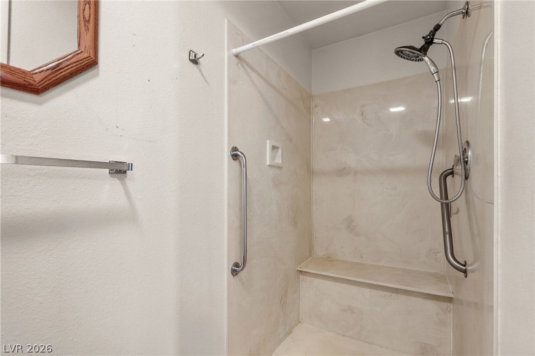5601 Paseo Recallo Court, Las Vegas, NV 89108 A built-in shower features integrated grab bars and a convenient bench seat.