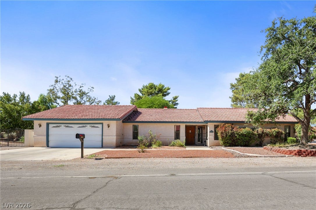 5601 Paseo Recallo Court, Las Vegas, NV 89108 Spanish tile roofing and stucco exterior walls create classic southwestern curb appeal.