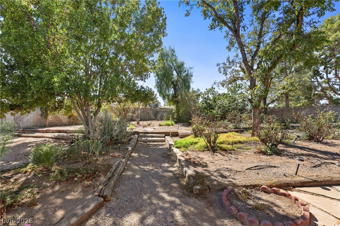 5601 Paseo Recallo Court, Las Vegas, NV 89108 Mature trees shade a peaceful garden path winding through the spacious property grounds.