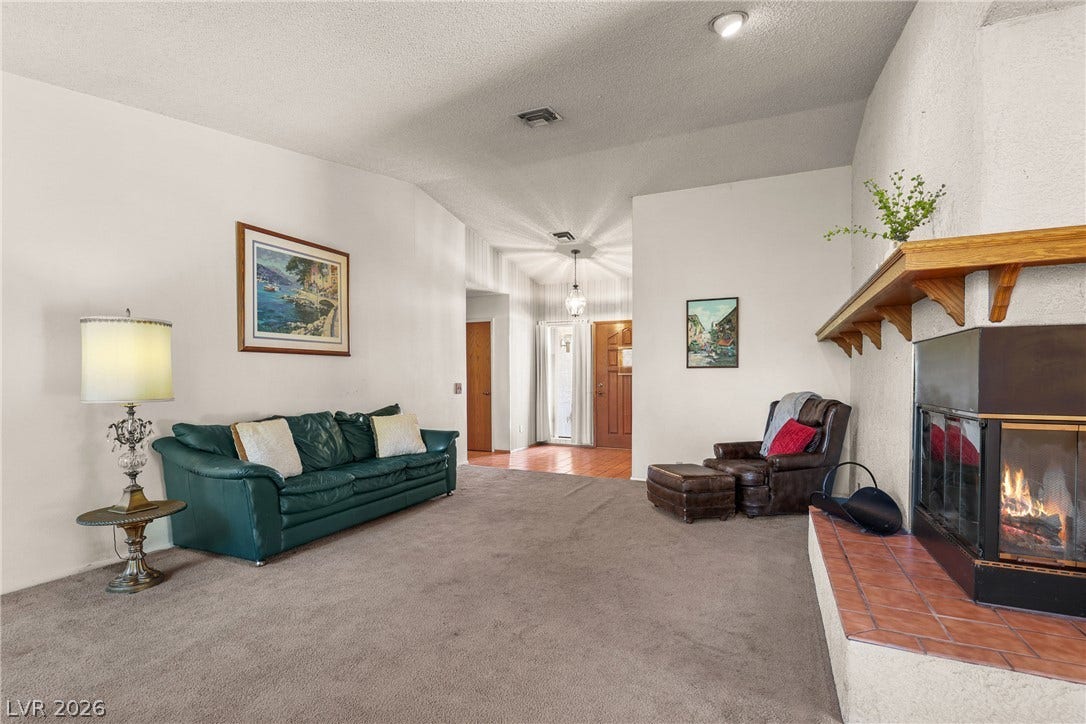5601 Paseo Recallo Court, Las Vegas, NV 89108 An inviting fireplace and vaulted ceilings anchor this comfortable main living space.