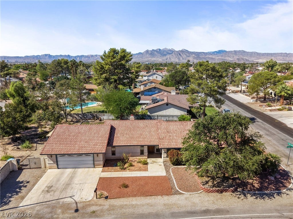 5601 Paseo Recallo Court, Las Vegas, NV 89108 A classic tile roof and concrete driveway define this single-level home set against mountain views.