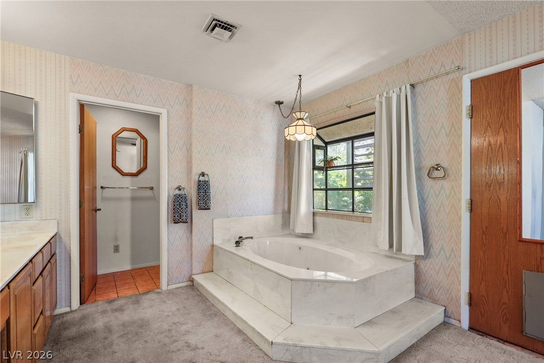 5601 Paseo Recallo Court, Las Vegas, NV 89108 An inviting soaking tub on a raised platform commands attention in this primary bath.