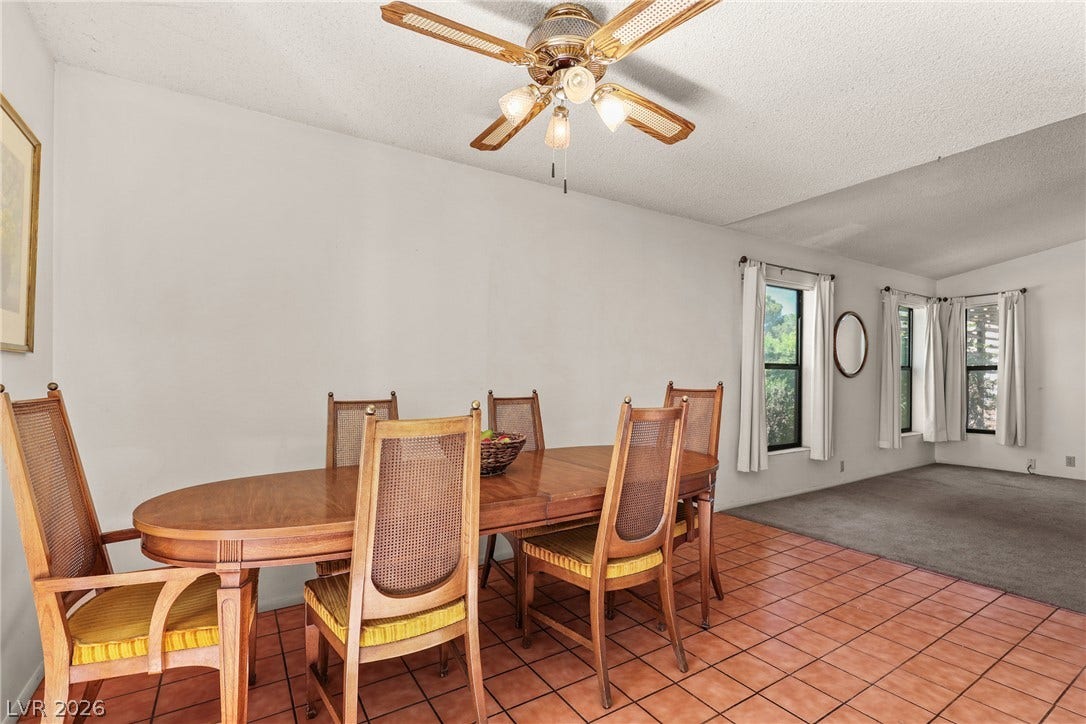5601 Paseo Recallo Court, Las Vegas, NV 89108 An open dining area flows into an adjacent carpeted living room through wide transitions.