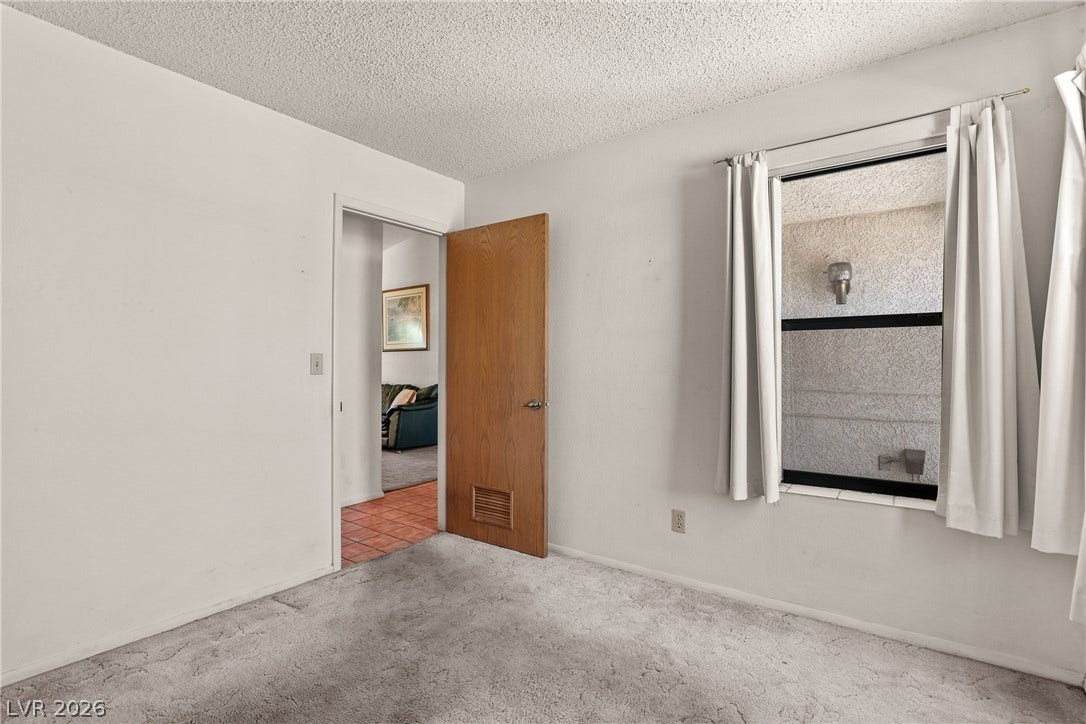 5601 Paseo Recallo Court, Las Vegas, NV 89108 A single window provides natural light to this carpeted bedroom.
