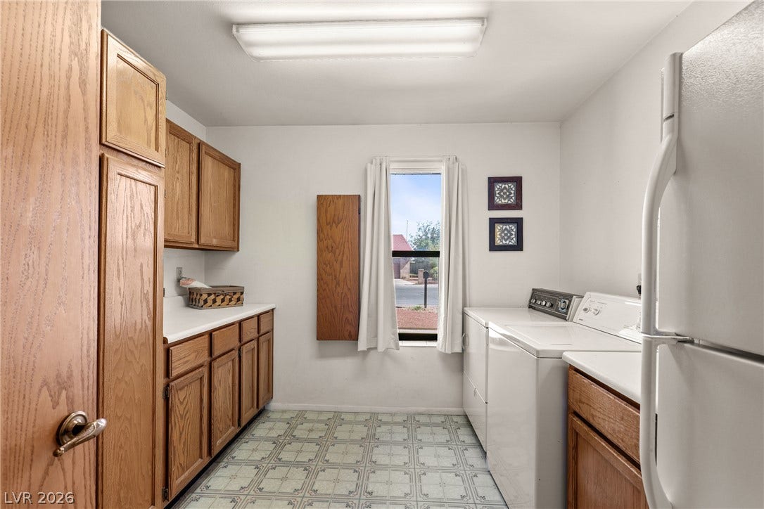 5601 Paseo Recallo Court, Las Vegas, NV 89108 Ample wooden cabinetry and classic patterned tile flooring define this functional home utility space.