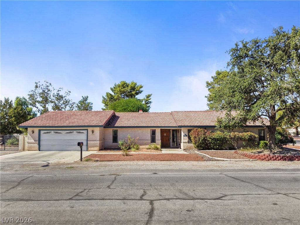 5601 Paseo Recallo Court, Las Vegas, NV 89108 A classic tile roof and low-profile ranch silhouette define this welcoming suburban exterior.