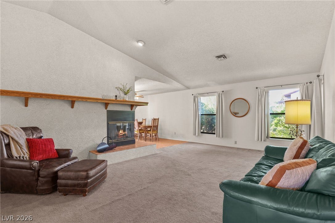 5601 Paseo Recallo Court, Las Vegas, NV 89108 Vaulted ceilings and a wood-burning fireplace create an inviting atmosphere in this main living space.