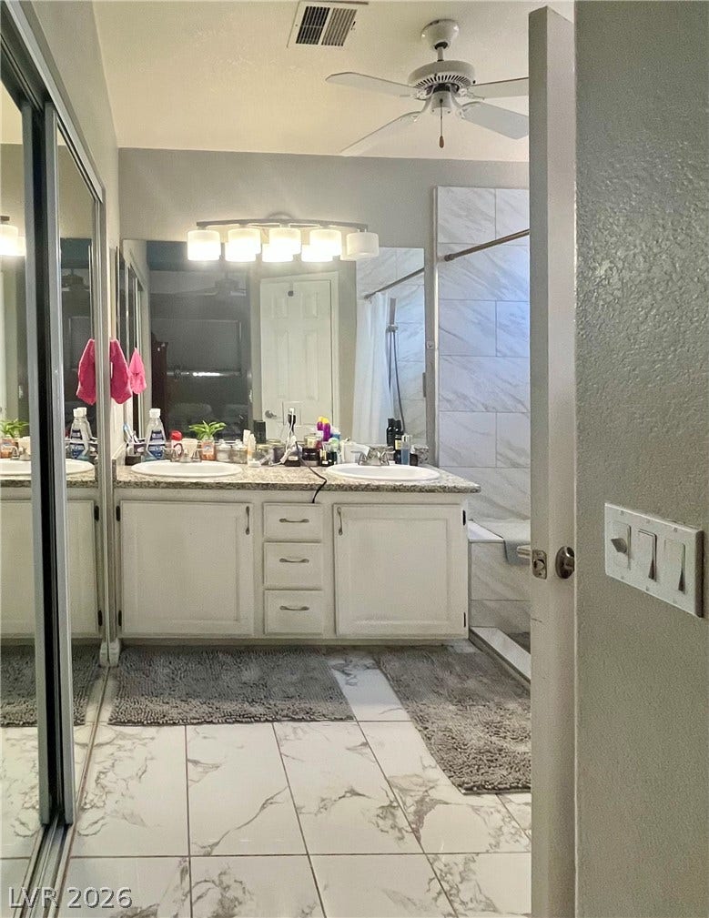 15 Rue des Champs, Henderson, NV 89074 A classic double vanity aligns with tiled flooring in this bright bathroom space.