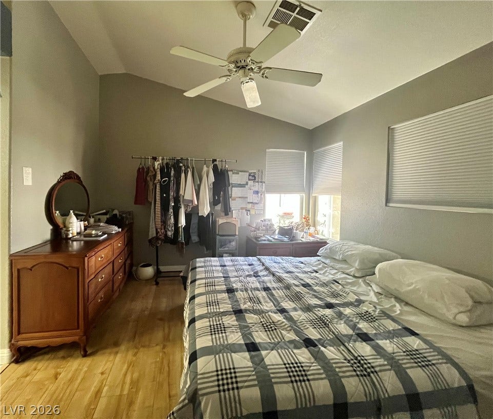 15 Rue des Champs, Henderson, NV 89074 Vaulted ceilings and warm wood-style flooring elevate this comfortable bedroom space.