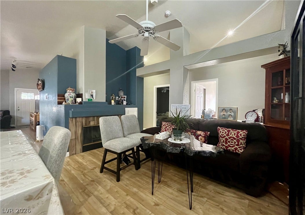 15 Rue des Champs, Henderson, NV 89074 A spacious living area displays high ceilings, a tiled fireplace, and hardwood flooring.