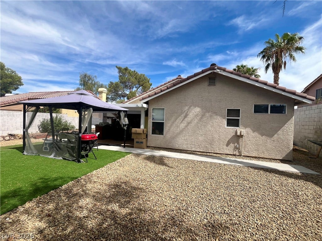 15 Rue des Champs, Henderson, NV 89074 Low-maintenance gravel landscaping and a paved walkway define this private backyard setting.