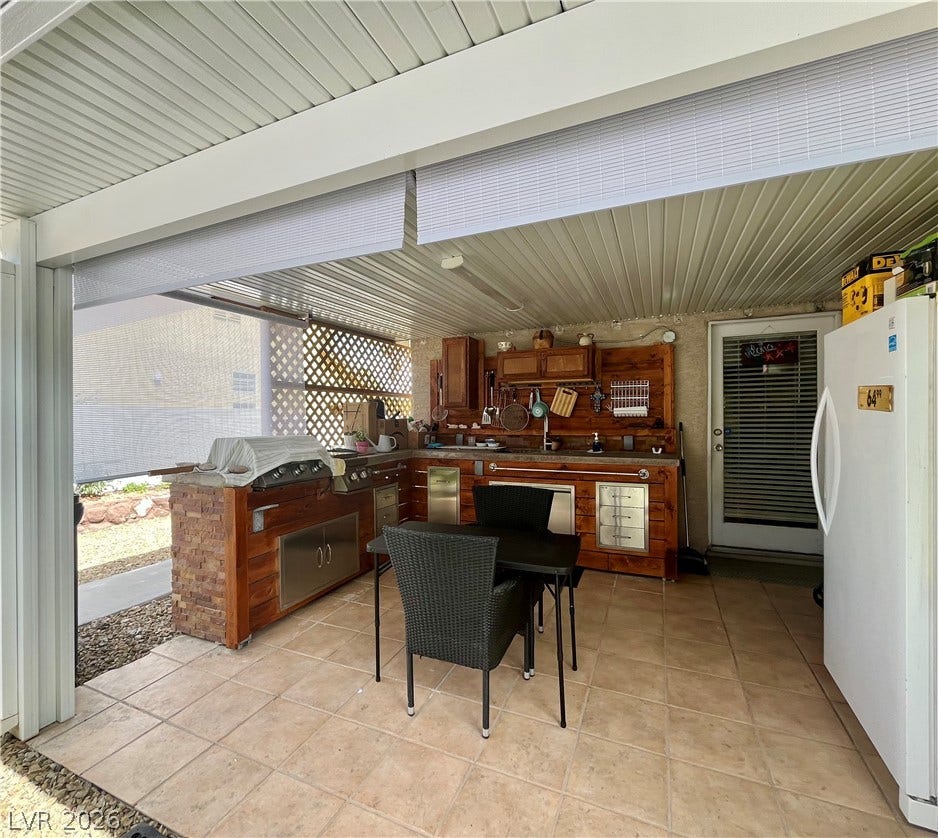 15 Rue des Champs, Henderson, NV 89074 Tiled flooring and a durable solid roof shelter this well-equipped outdoor culinary space.