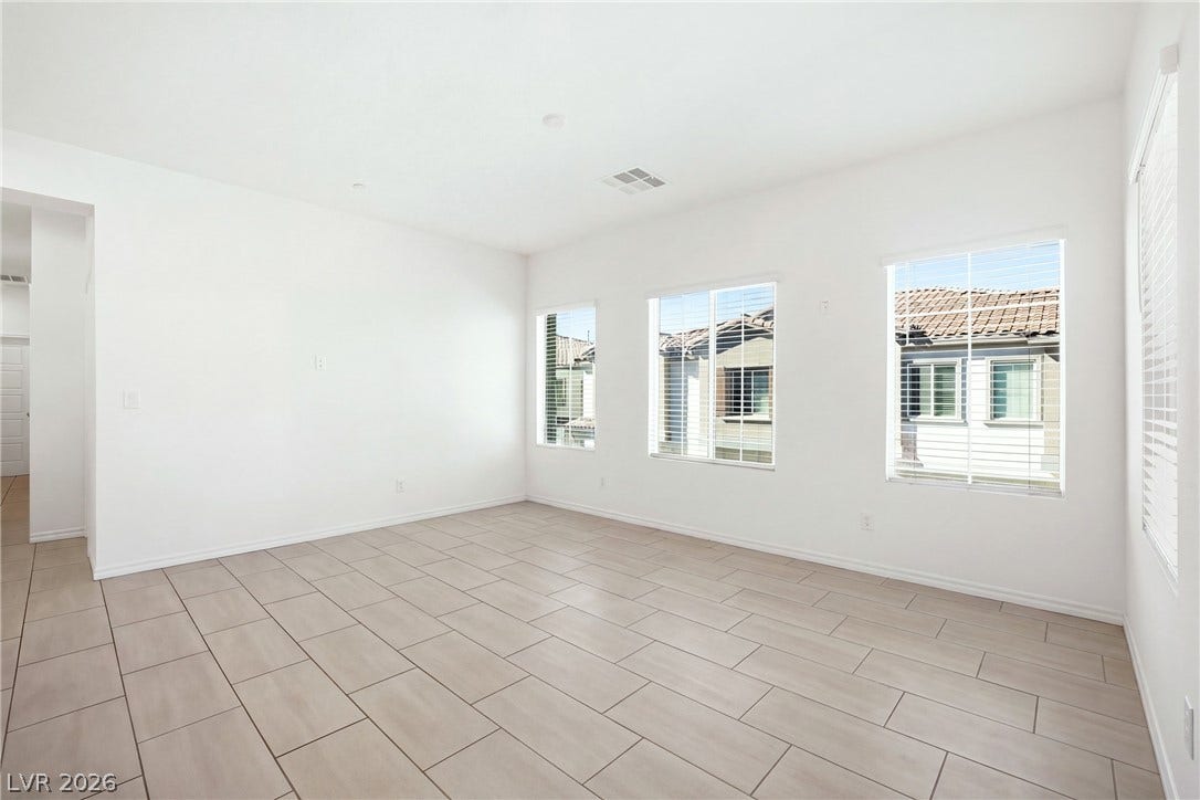 Tiled flooring and large windows create a clean, minimalist backdrop in this versatile living space.