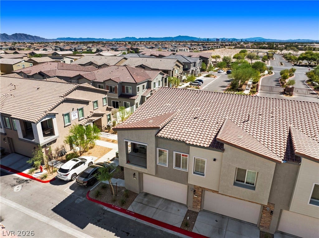 Tiled roofs and multi-level design define this contemporary residential neighborhood under clear desert skies.