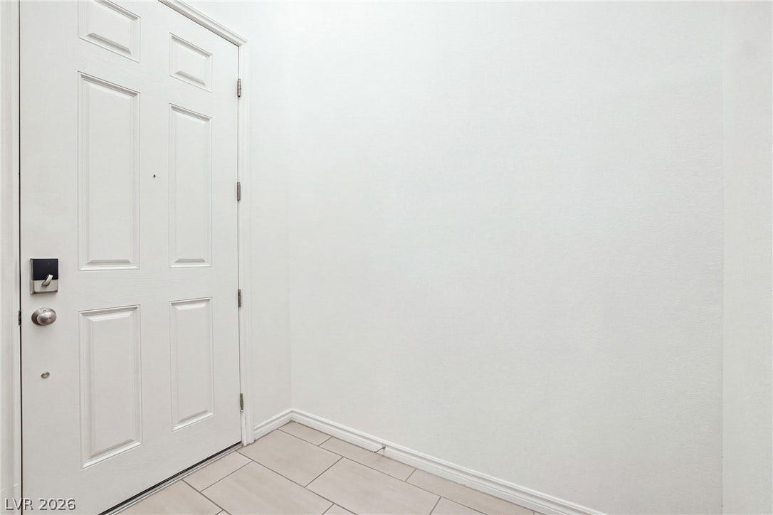 Tiled flooring and a classic paneled door define this welcoming entryway space.