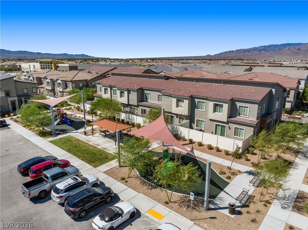 A well-planned community setting includes pedestrian pathways alongside residential structures and structured playgrounds.