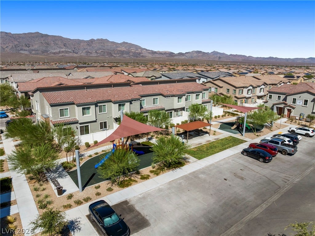 A well-maintained community park and playground area sits adjacent to multi-family residential structures.