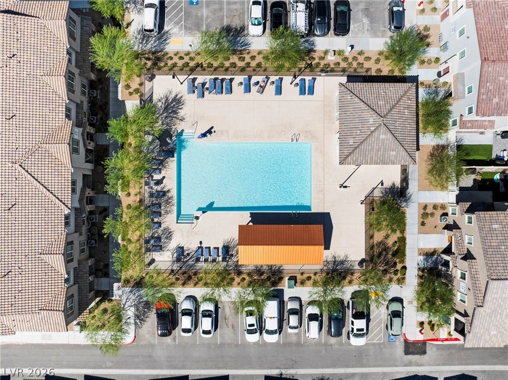 An aerial perspective captures a sparkling community swimming pool surrounded by manicured pathways.