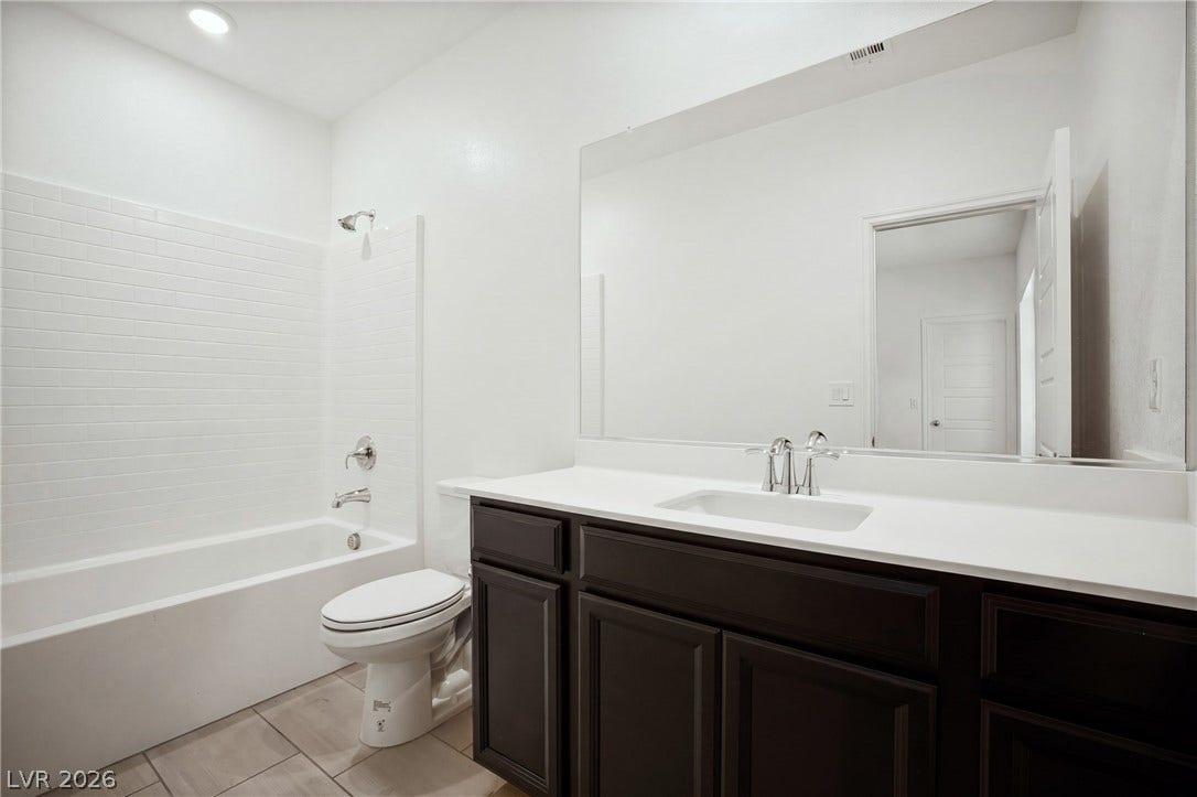 Clean lines and a spacious vanity highlight this modern bathroom with classic subway tile.