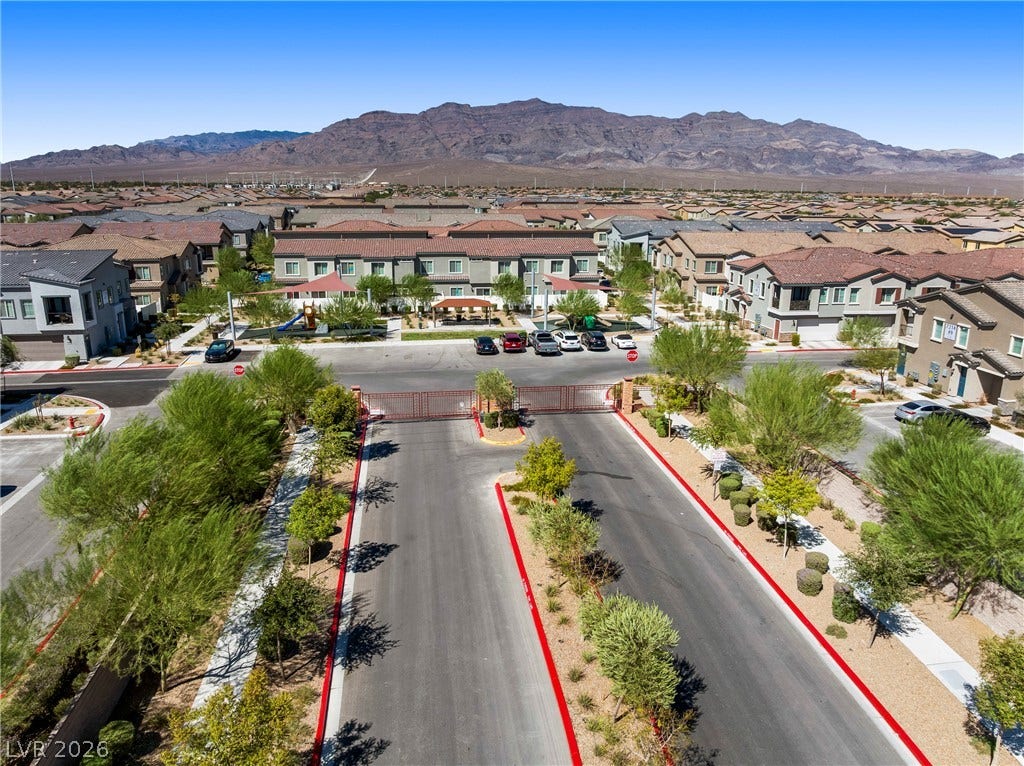 Dramatic mountain peaks frame this gated residential community under clear desert skies.
