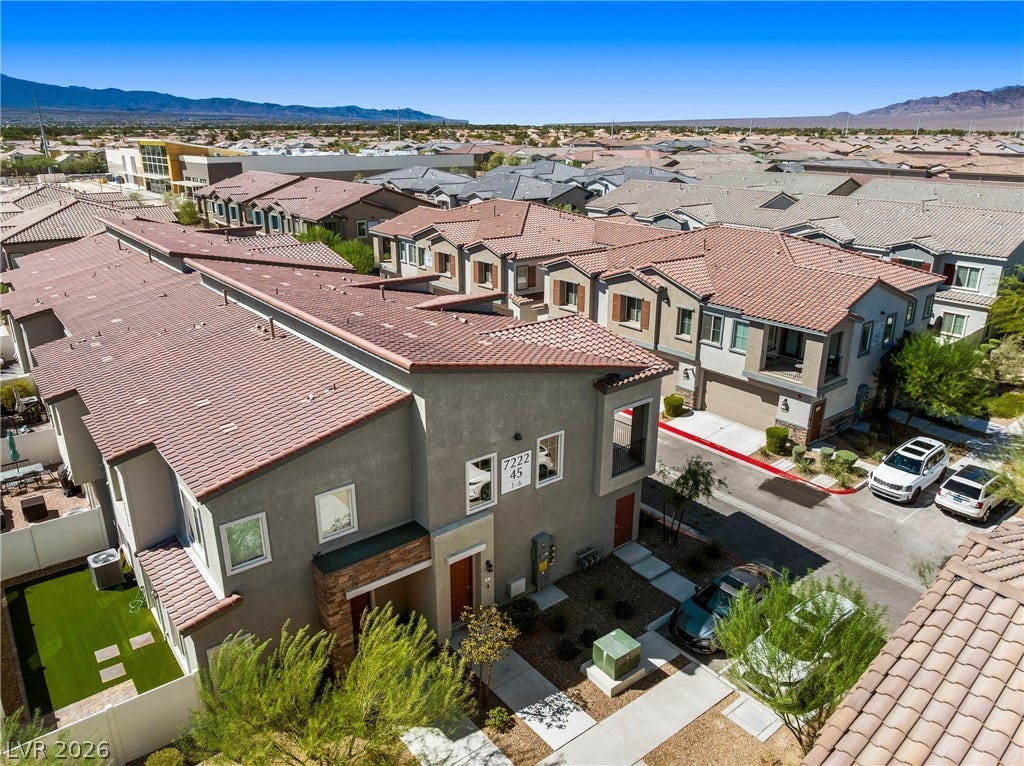 Spanish tile roofs and stucco exteriors define this modern residential development nestled near mountain ridges.