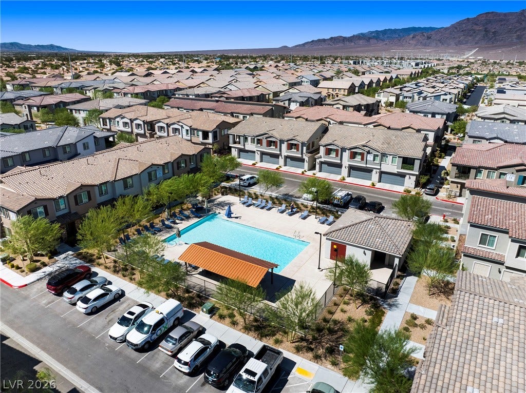 A sparkling community pool offers recreation options against a backdrop of distant desert mountains.