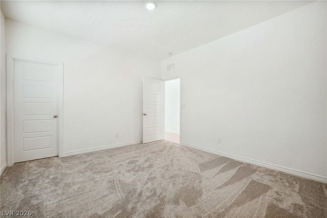 Plush carpeting and clean white walls define this versatile secondary space.