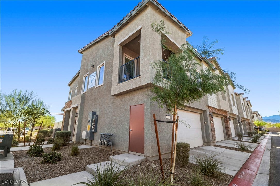 Stucco siding and concrete driveways define this modern multi-level townhouse exterior.