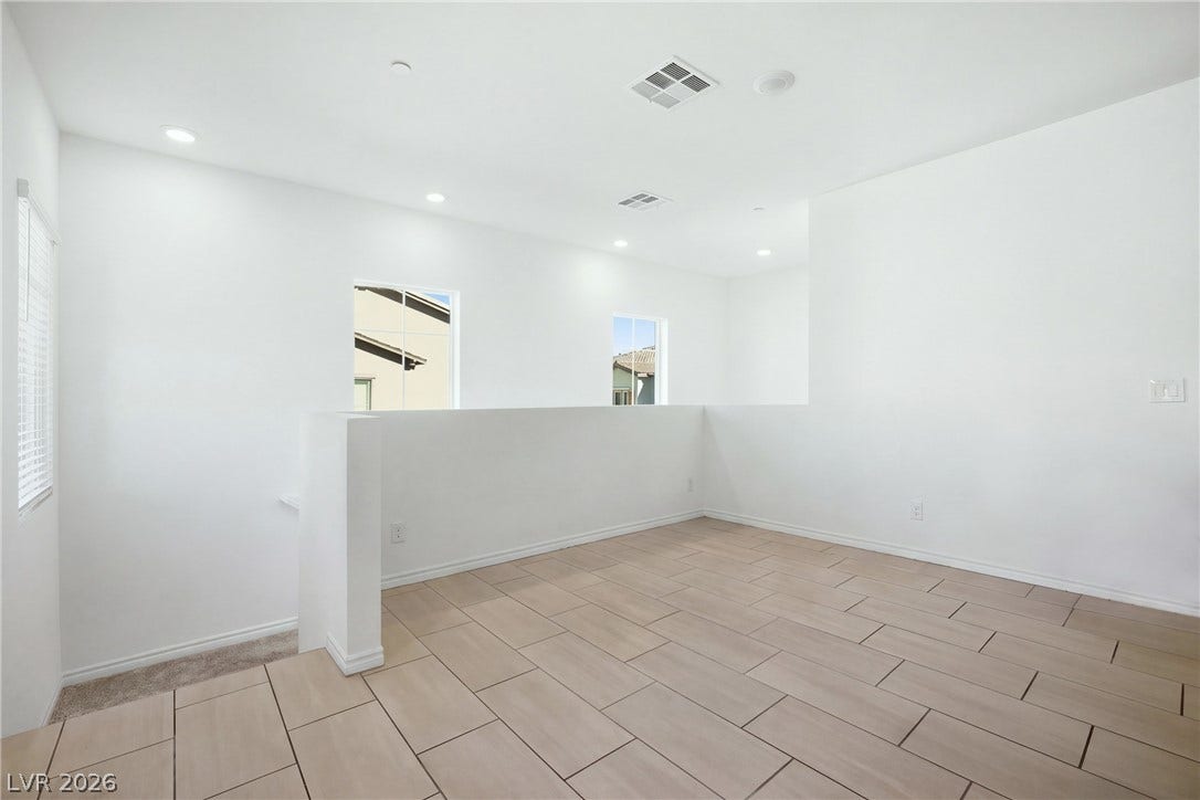 Gleaming tile floors and crisp white walls define this versatile upper-level loft space.