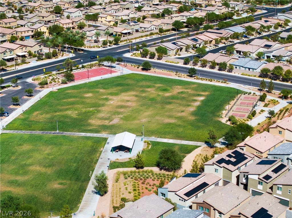 An expansive green park features basketball courts, tennis courts, and a covered pavilion.