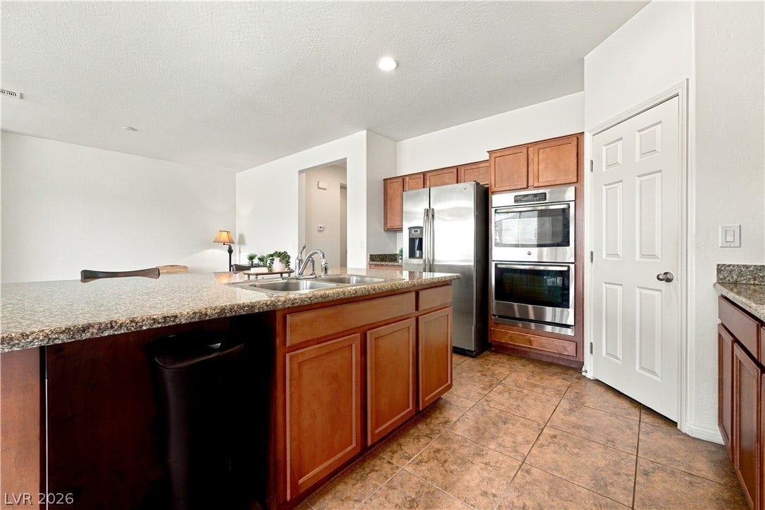 4209 Fairywren Drive, North Las Vegas, NV 89031 Granite countertops paired with classic wood cabinetry anchor this spacious culinary workspace.