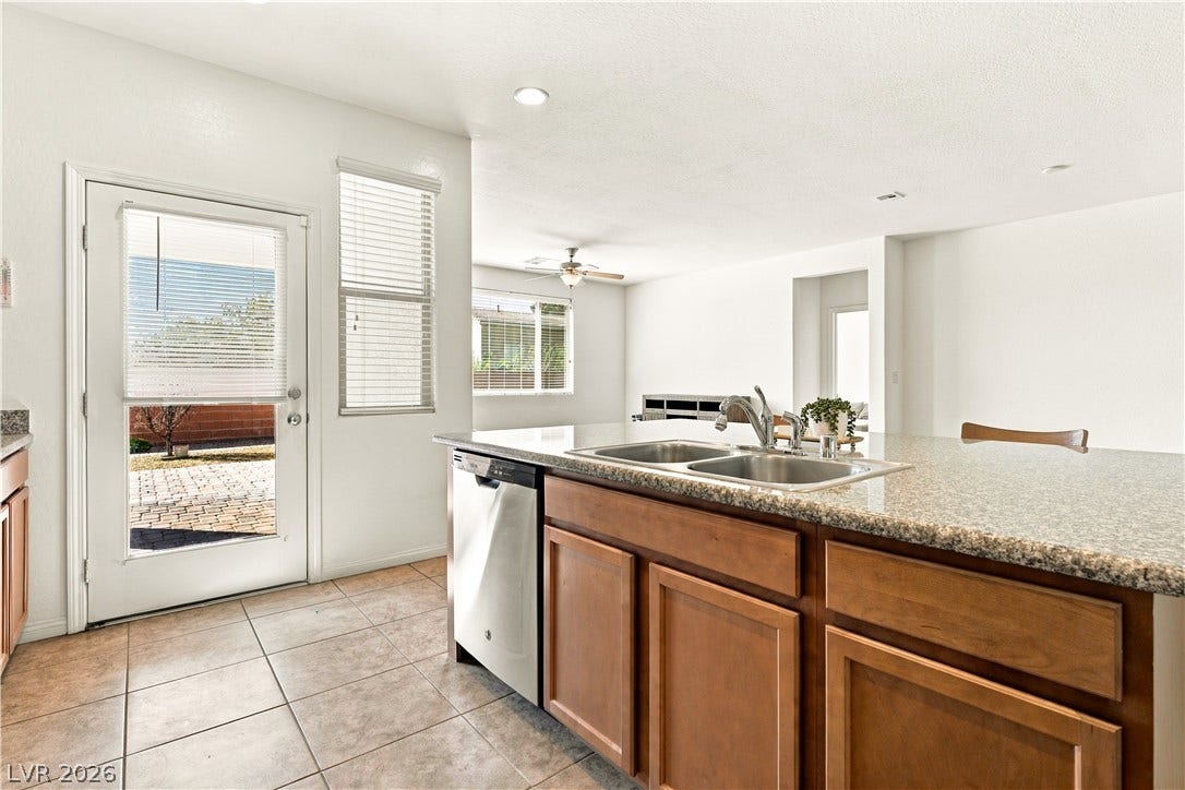 4209 Fairywren Drive, North Las Vegas, NV 89031 Gleaming stone countertops and ceramic tile flooring define this bright, open kitchen space.