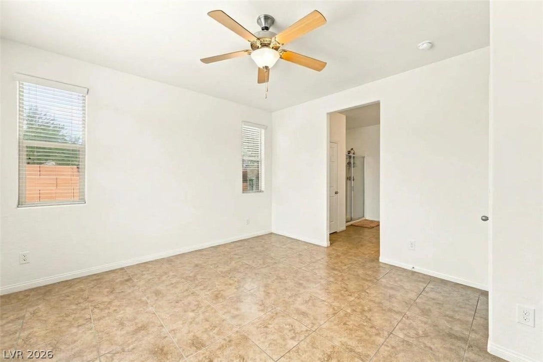 4209 Fairywren Drive, North Las Vegas, NV 89031 Tiled flooring and large windows create a bright foundation in this versatile bedroom space.