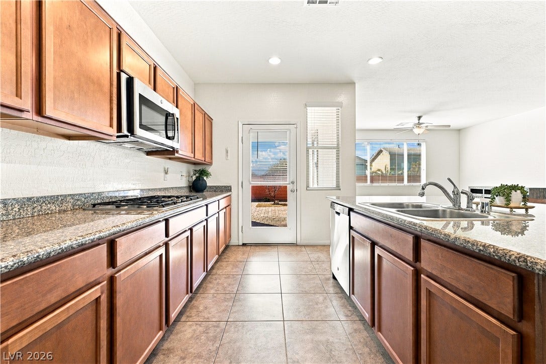 4209 Fairywren Drive, North Las Vegas, NV 89031 Rich wood cabinetry and speckled stone countertops define this well-appointed culinary space.