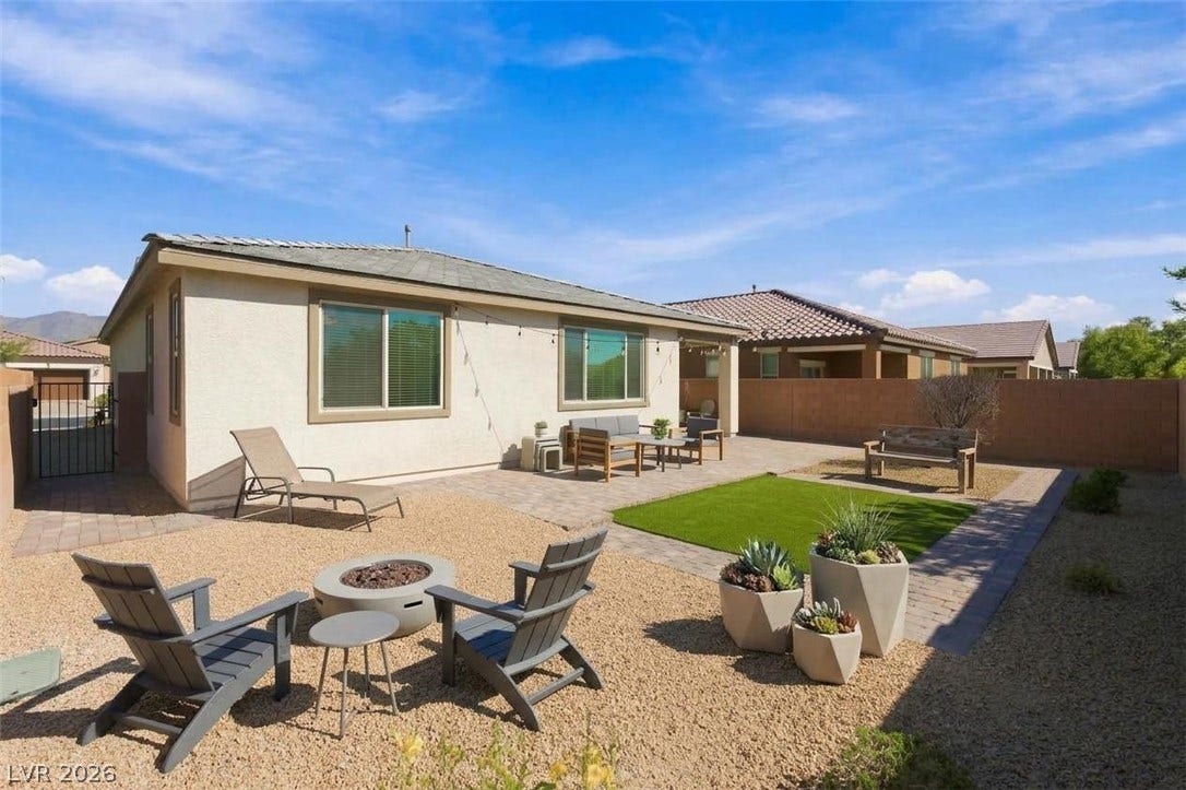 4209 Fairywren Drive, North Las Vegas, NV 89031 A low-maintenance backyard features a stone paver patio and a fire pit area.