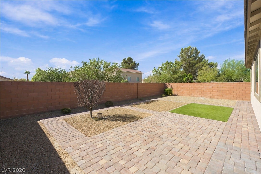 4209 Fairywren Drive, North Las Vegas, NV 89031 An enclosed backyard features meticulous paver block patios and low-maintenance landscaping under open desert skies.